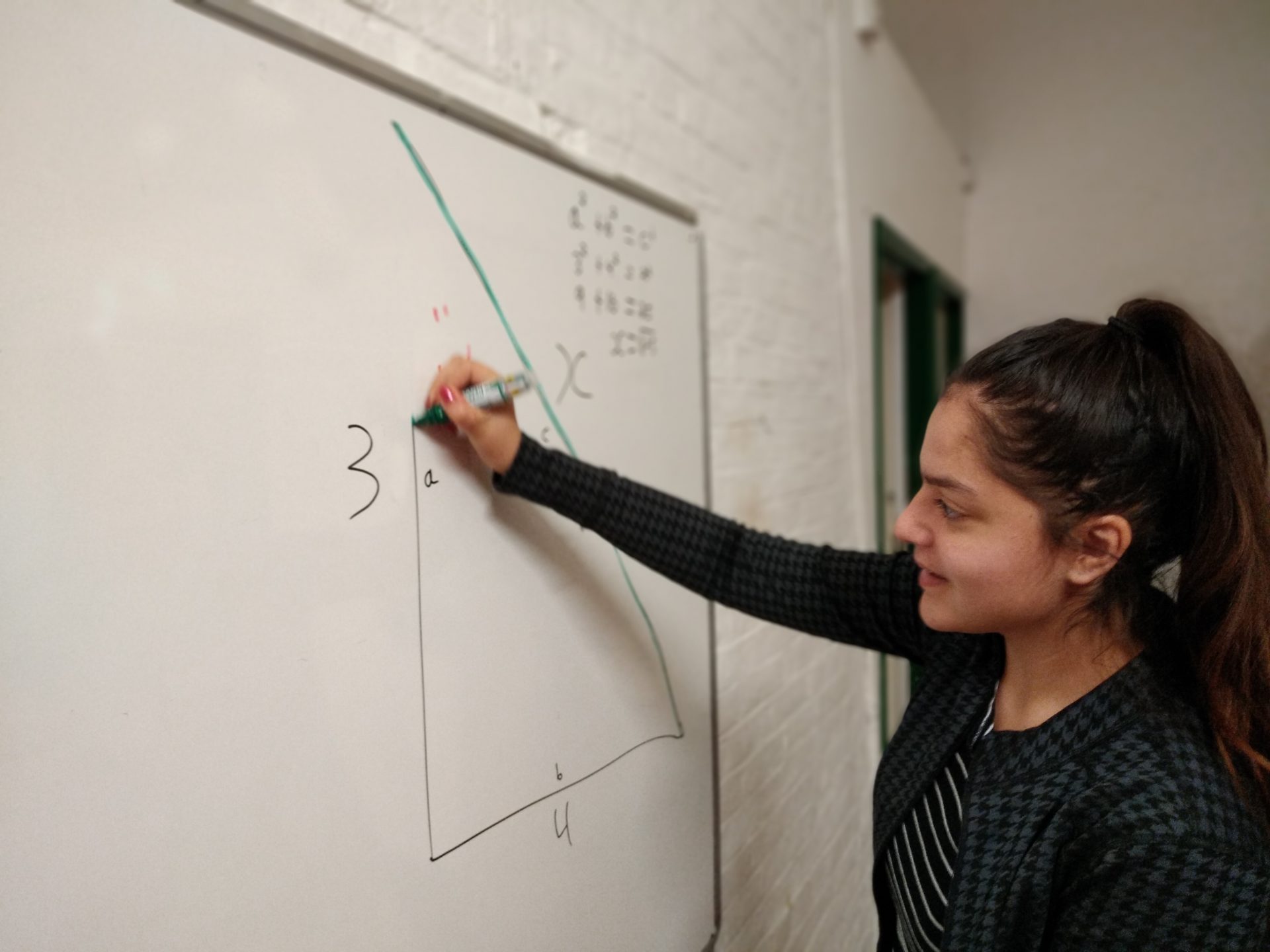 Student drawing triangle on white boards